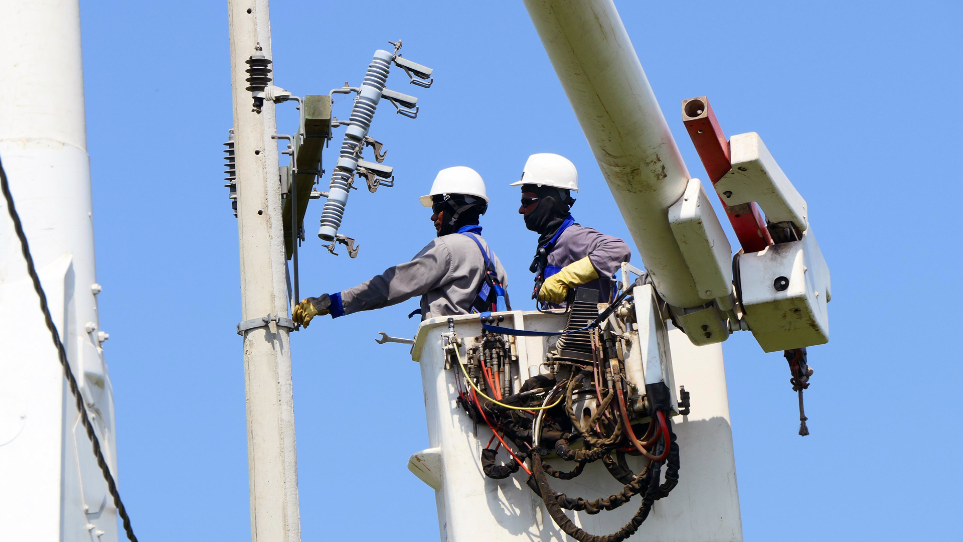 Operarios trabajando en un poste de energía 