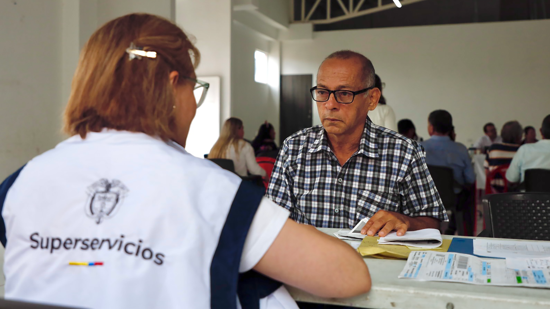 Funcionaria de la Superservicios atendiendo a un usuario con una solicitud de asesoría sobre un servicios público 