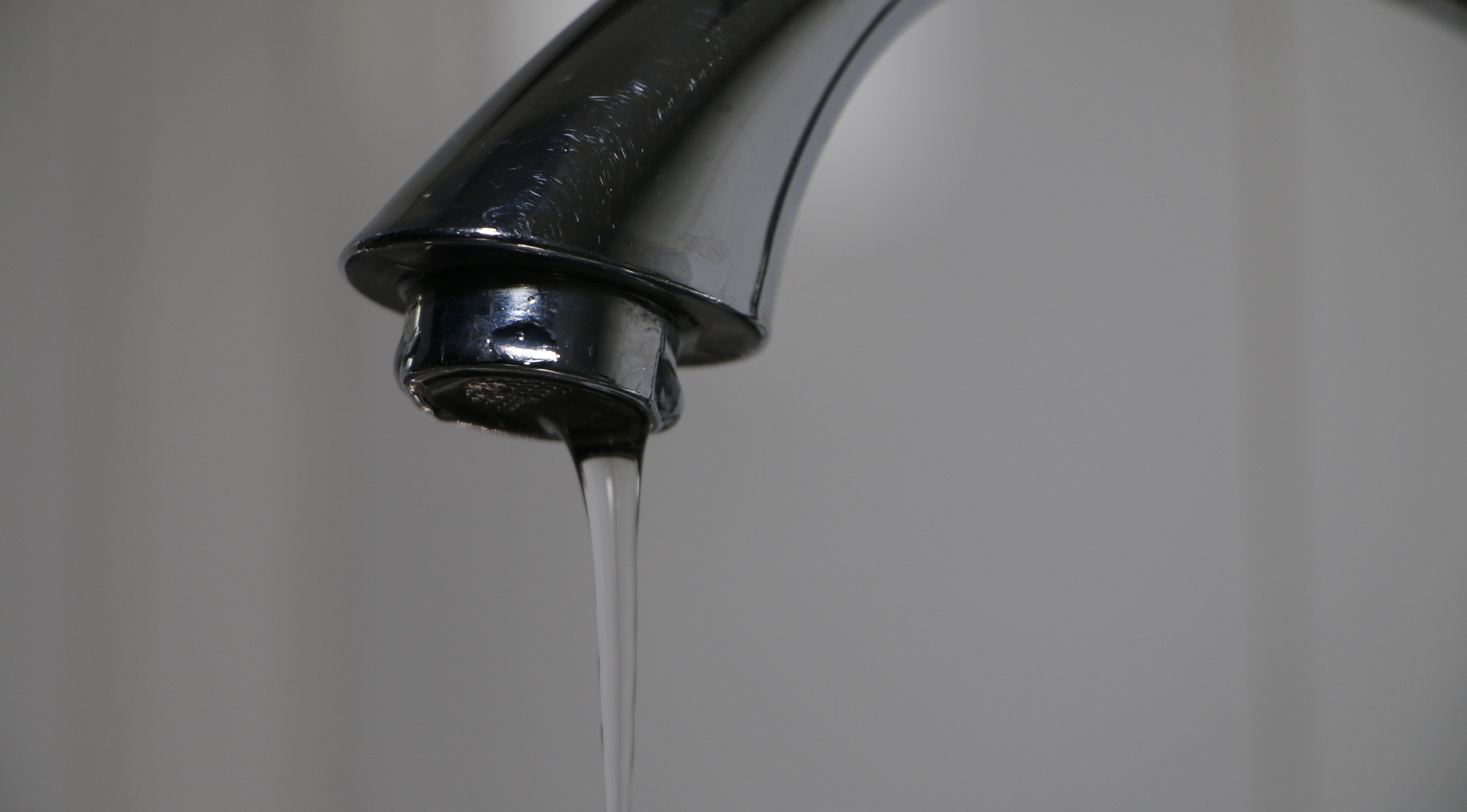 Grifo de lavamanos con agua cayendo