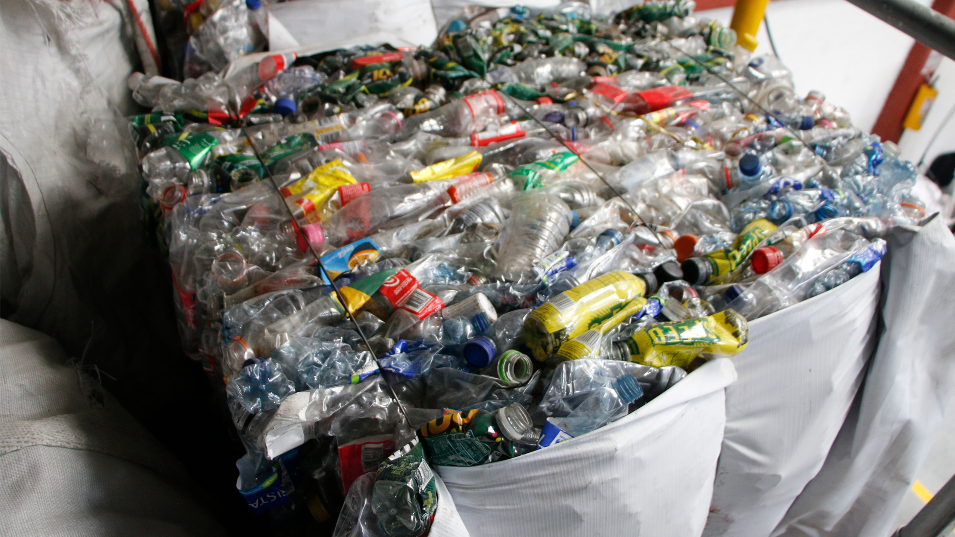 Pila de botellas de plástico reciclado, apiladas en un almacén