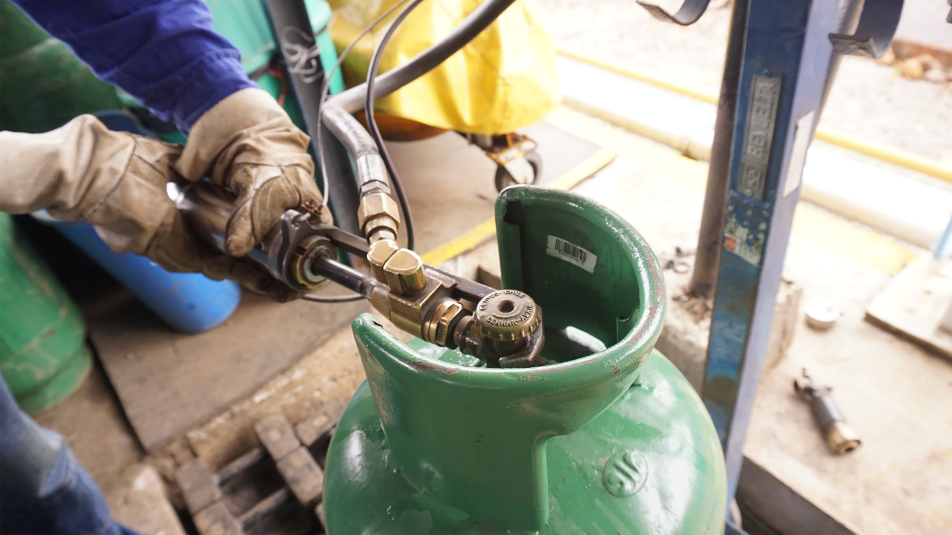 Individuo utilizando una manguera para llenar un tanque de gas, mostrando concentración en el proceso de abastecimiento.