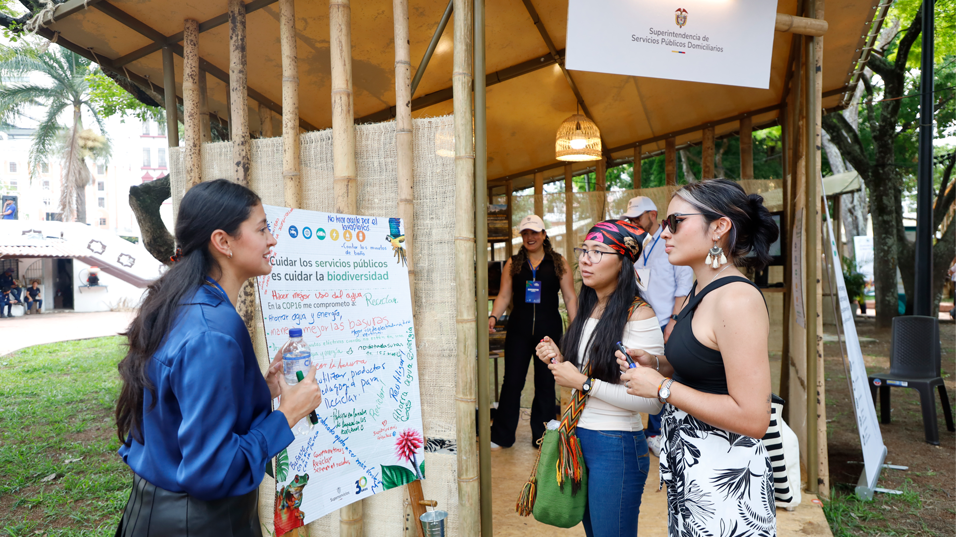 Visitantes al stand de la Superservicios conociendo recomendaciones para cuidar el medio ambiente.